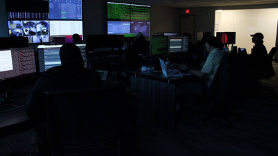 Team monitoring data in dark office space